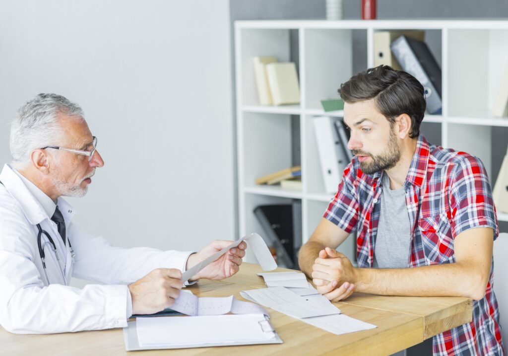 Doctor consulting a young man during a medical appointment, discussing men's health