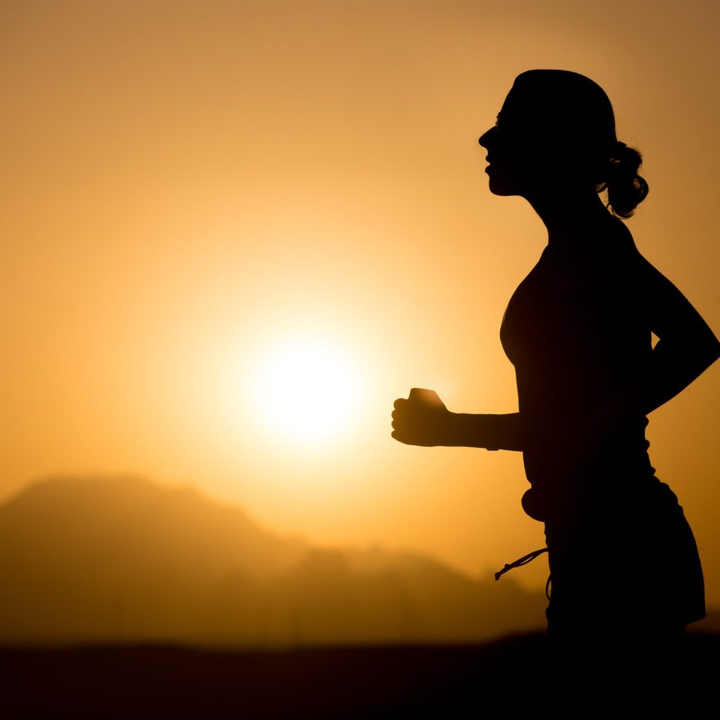 Silhouette of a woman running at sunset